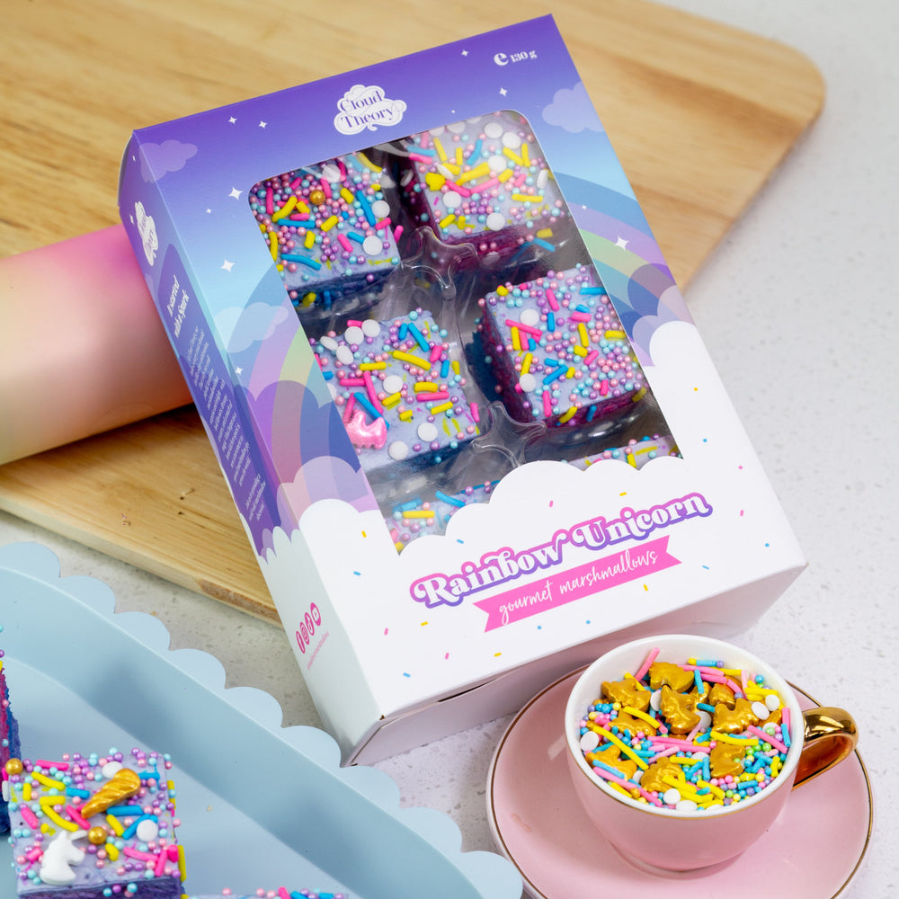 Packaged dessert with rainbow sprinkles on a wooden board and white surface