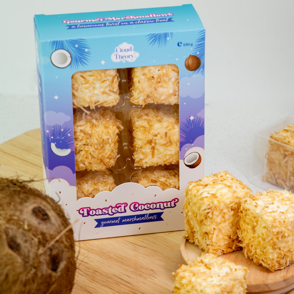 Box of Toasted Coconut marshmallows with marshmallows on a wooden surface